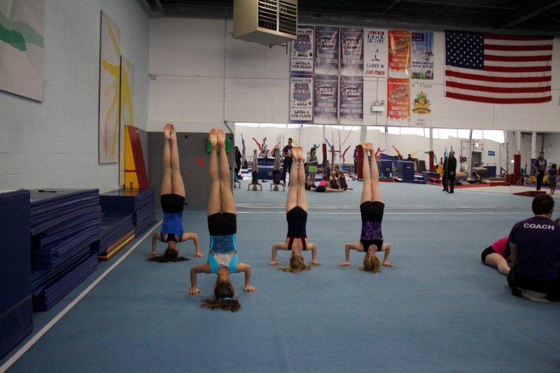 Four gymnasts doing headstands.